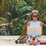woman working freelance jobs on a laptop while on vacation