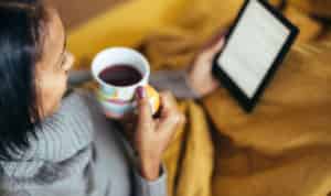 woman reading ebook while sipping coffee